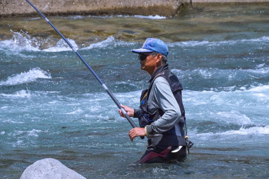 鮎の友釣り(川に立ち込む釣り人)